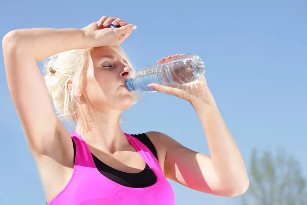 Femme avec bouteille d'eau sent la chaleur de l'été — Photo