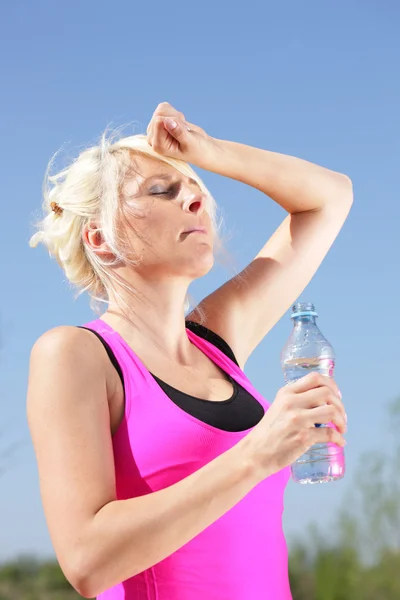 Kobieta z butelka wody czuje się upalne lato — Zdjęcie stockowe