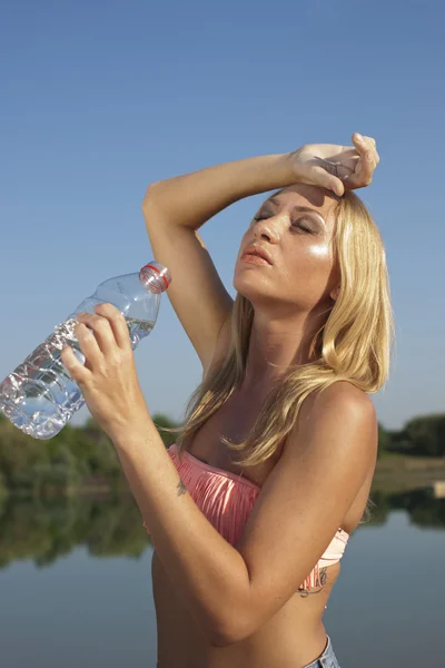 Mladá žena pitnou vodu v horkém létě — Stock fotografie