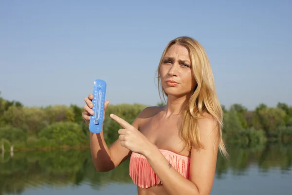 Молодая женщина с термометром летом — стоковое фото