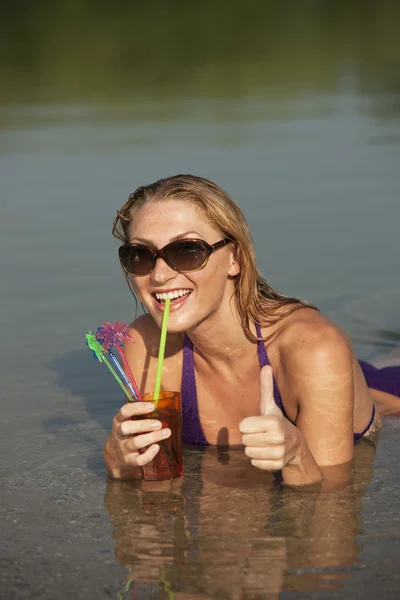 Happy woman with cool drink in the water — Stock Photo, Image