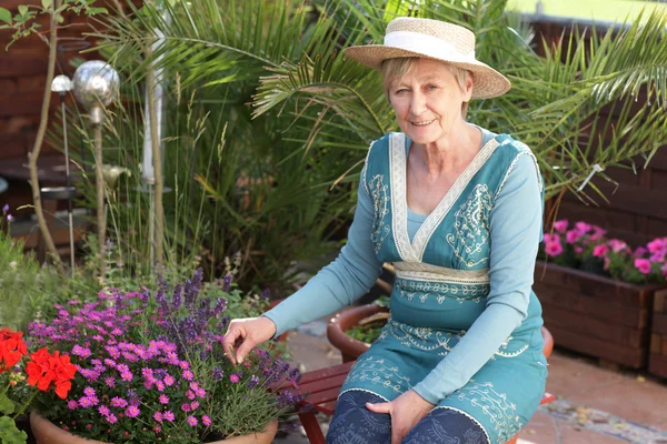 Mulher sênior feliz com flores — Fotografia de Stock