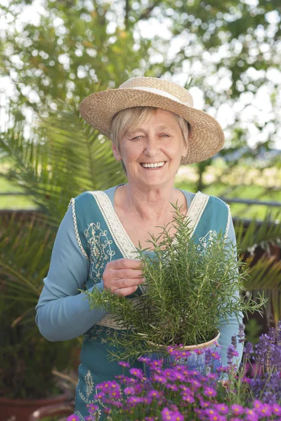 Χαρούμενη ηλικιωμένη γυναίκα με λουλούδια — Φωτογραφία Αρχείου