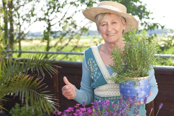 Mulher sênior feliz com flores — Fotografia de Stock