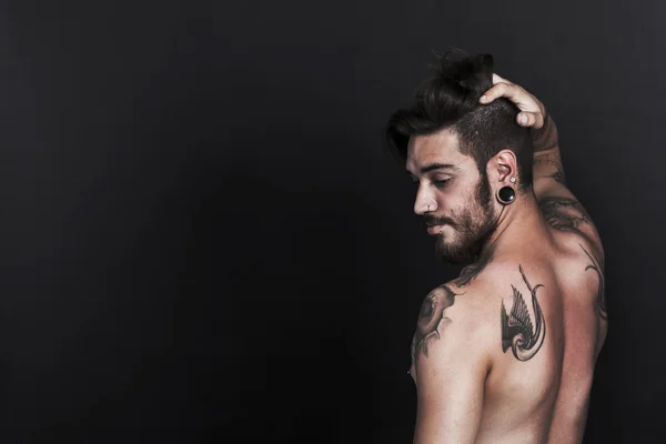 Vážný mladík městských s tetování pohled z boku — Stock fotografie