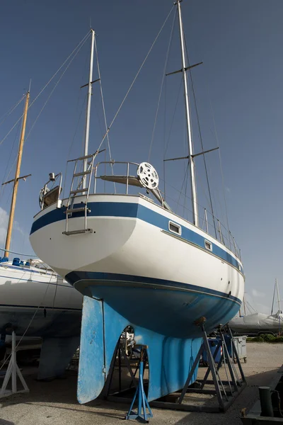 Blaues Boot am Dock für Wartungsarbeiten lizenzfreie Stockfotos