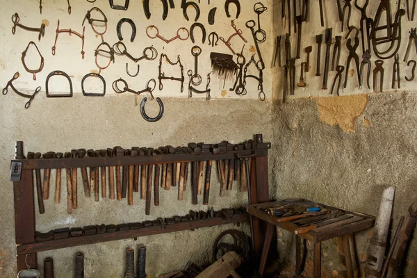 Wall with tools for horseshoes — Stock Photo, Image