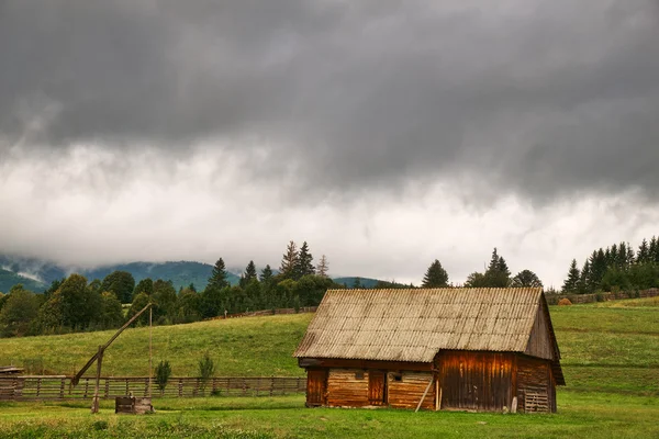 Hütte auf dem Feld und bewölkter Himmel — Stockfoto