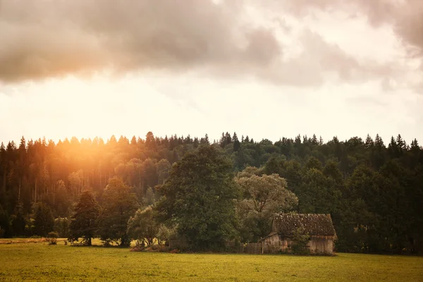 Cabine op het veld en bewolkte hemel — Stockfoto