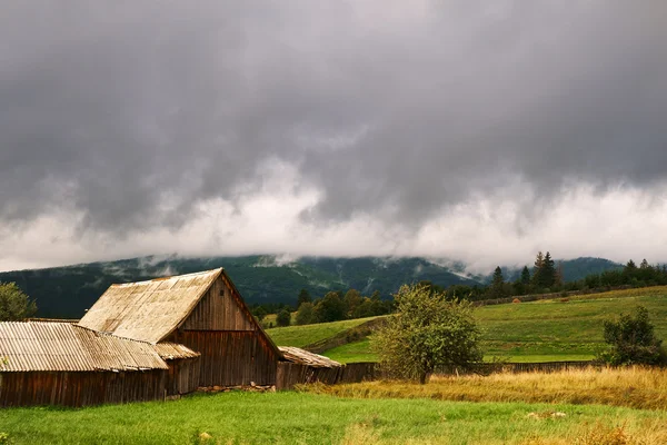 Cabin on the field and cloudy sky — Stock Photo, Image