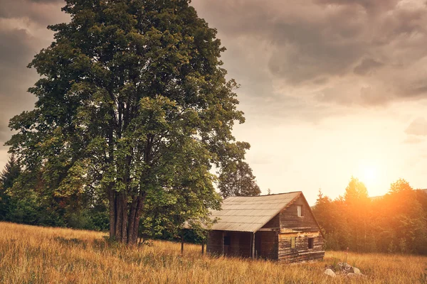 Cabine op het veld en bewolkte hemel — Stockfoto