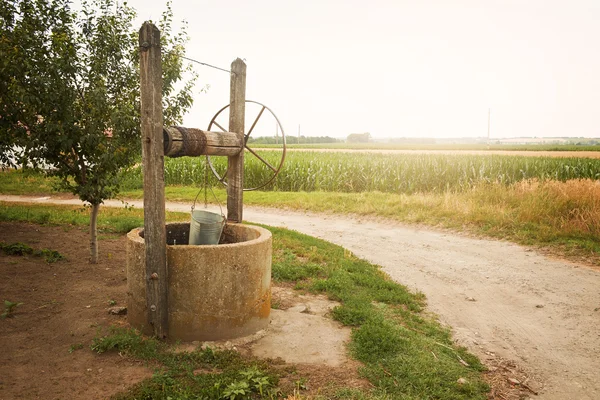 Bien cerca de la carretera en el villiage — Foto de Stock