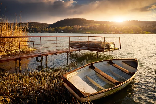 Лодка на озере возле пирса — стоковое фото