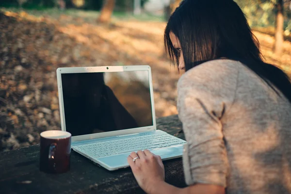 Dívka a notebook v parku — Stock fotografie