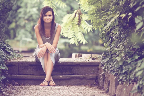 Frau sitzt im Park — Stockfoto