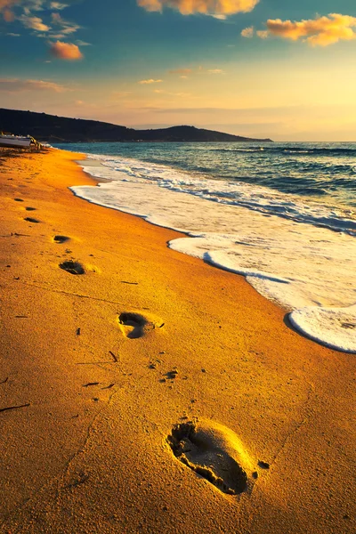 Empreintes de pas sur la plage au coucher du soleil — Photo