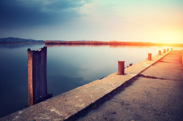 Jetty i kyst nær vann – stockfoto