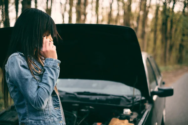 Женщина с каштановыми волосами возле машины — стоковое фото