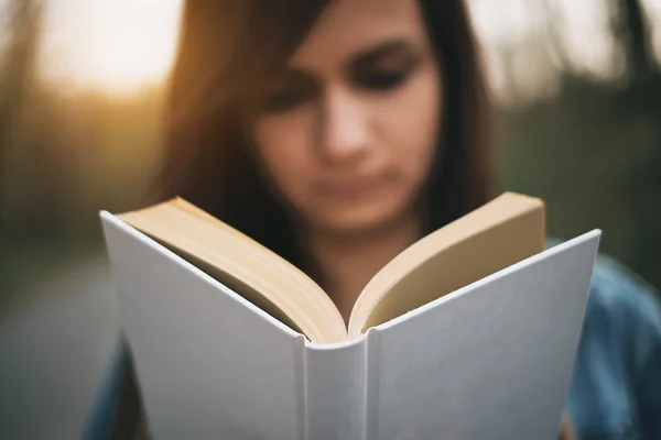 Ung kvinna läser bok — Stockfoto