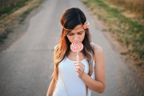 Giovane, donna bruna mangiare lecca-lecca — Foto Stock