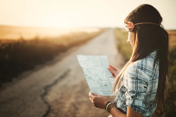 Traveler hippie girl looking on map