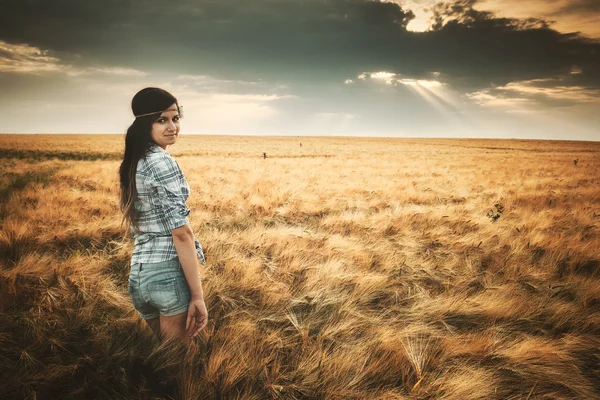 Jonge, brunette vrouw op veld — Stockfoto