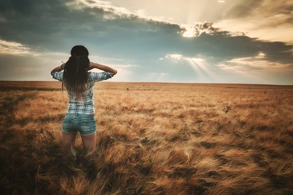 Jonge, brunette vrouw op veld — Stockfoto