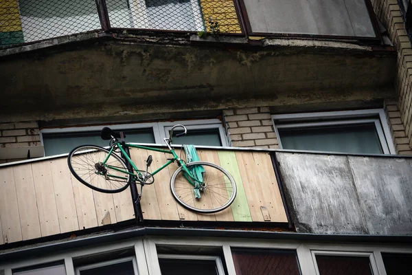 背の高い古い黄色のレンガの壁の建物のバルコニーにかかって自転車 — ストック写真