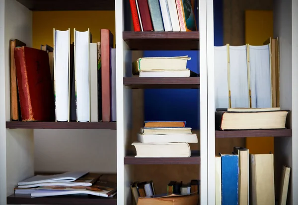 Багато книг стоять і лежать на полицях — стокове фото