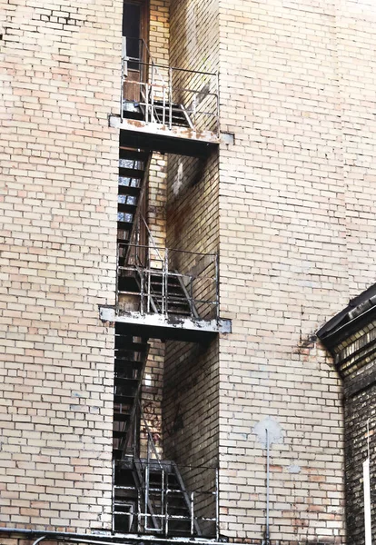Vieja escalera de ecape fuego visto a través de en el edificio de ladrillo blanco — Foto de Stock