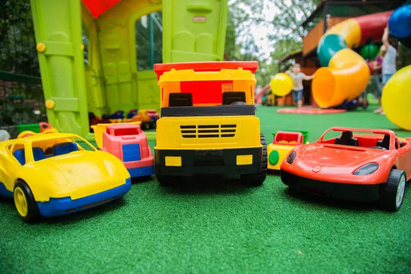 五辆不同的儿童车半圆形地站在绿色的地板上 儿童玩具 — 图库照片