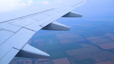 Uçak tarlaların üzerinde uçuyor.