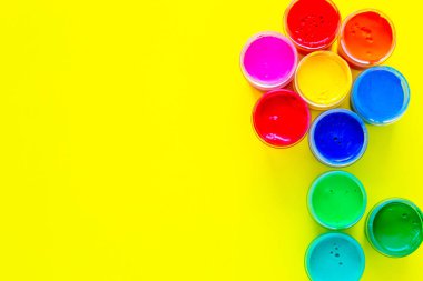 Sarı arkaplandaki boya kavanozlarından oluşan yaratıcı bir çiçek ve yazı için bir yer. Üst görünüm, düz görünüm, kopyala boşluk, izole et