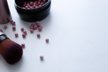 Kızaran pembe ve krem rengi toplar ve beyaz bir arka plana yazı için allık sürmek için bir fırça. Üst görünüm, düz görünüm, kopyala boşluk, izole et