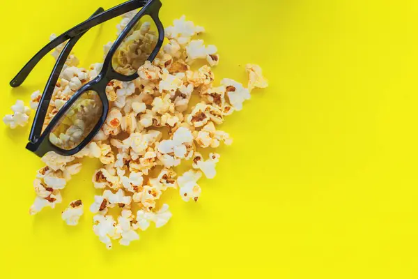 In the upper corner there are glasses on popcorn on a yellow background. top view, flat lay, copy space, isolate — Stock Photo, Image