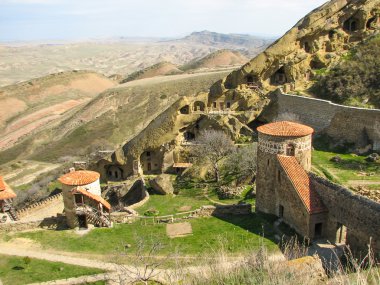 Açık mavi gökyüzü altında sarı çim kaplı tepe