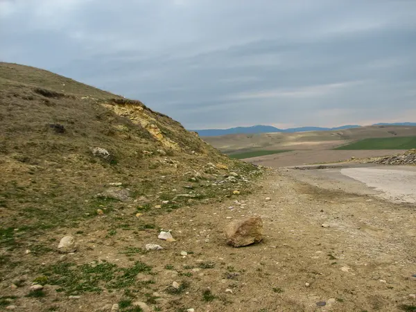 Açık mavi gökyüzü altında sarı çim kaplı tepe — Stok fotoğraf