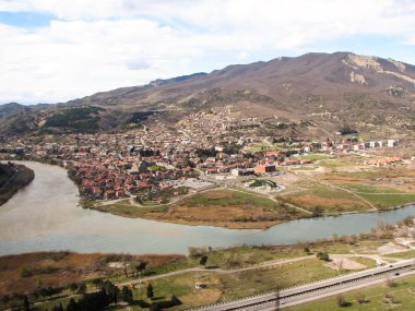 Açık mavi gökyüzü altında sarı çim kaplı tepe