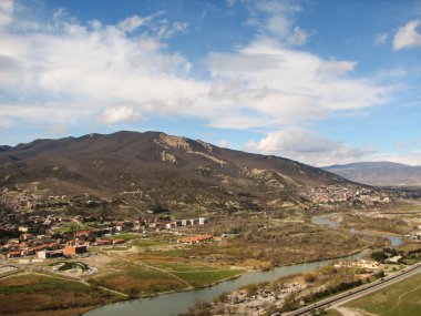 Açık mavi gökyüzü altında sarı çim kaplı tepe