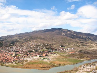 Açık mavi gökyüzü altında sarı çim kaplı tepe