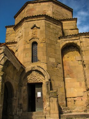 Açık mavi gökyüzü altında sarı çim kaplı tepe