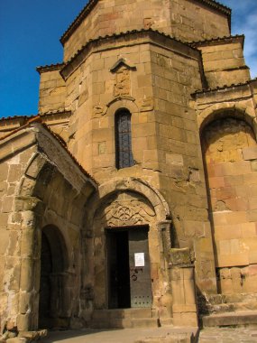 Açık mavi gökyüzü altında sarı çim kaplı tepe