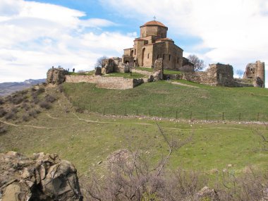 Açık mavi gökyüzü altında sarı çim kaplı tepe