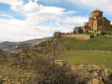Açık mavi gökyüzü altında sarı çim kaplı tepe
