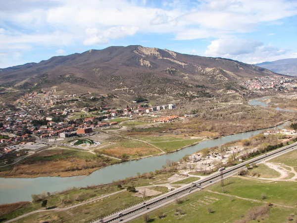 Açık mavi gökyüzü altında sarı çim kaplı tepe