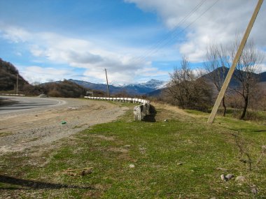 Açık mavi gökyüzü altında sarı çim kaplı tepe