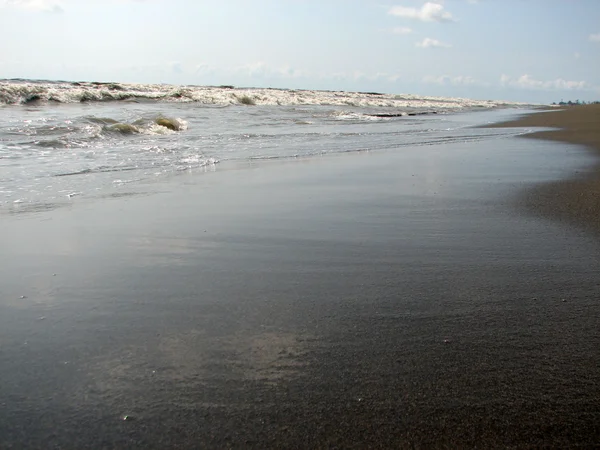 Szép nagy hullám, fekete homokos strandon — Stock Fotó
