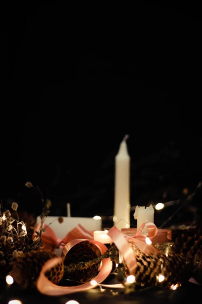 Decoraciones navideñas rosas con velas sobre fondo negro — Foto de Stock