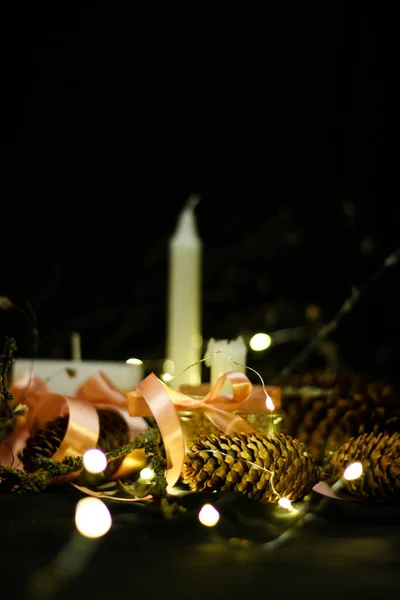 Decorações de Natal rosa com velas em um fundo preto — Fotografia de Stock