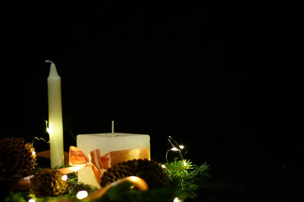 Decoraciones navideñas rosas con velas sobre fondo negro — Foto de Stock